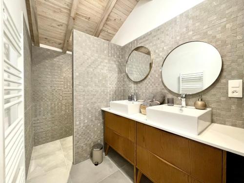 ein Badezimmer mit zwei Waschbecken und einem Spiegel in der Unterkunft Maison moderne idéale famille à 10 mn de la plage in Labenne