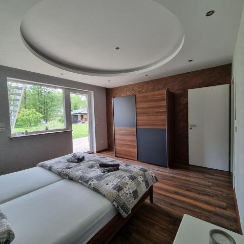 1 dormitorio con cama y ventana grande en Ferienwohnung am Kupferbach 