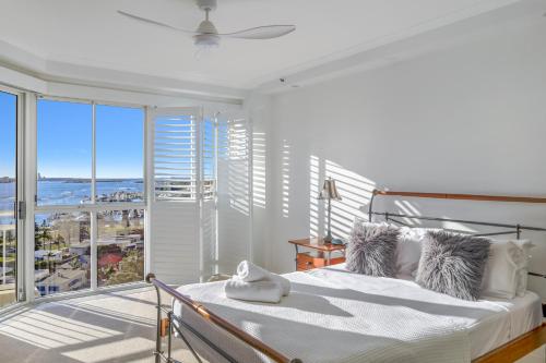 Dormitorio blanco con cama y ventana grande en Ocean Sands Resort, en Gold Coast