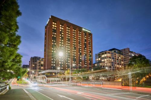 a city street with a tall building at night at Pullman Melbourne On the Park in Melbourne