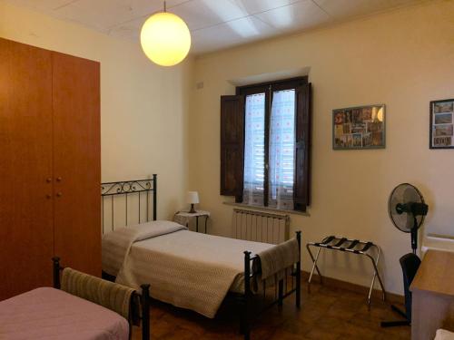 1 Schlafzimmer mit 2 Betten und einem Fenster in der Unterkunft Appartamento il Leone in Empoli