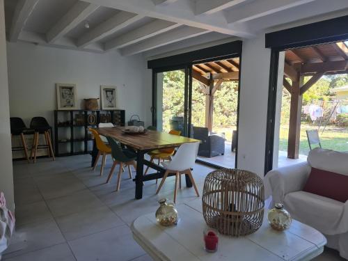 un salon avec une table et des chaises en bois dans l'établissement Villa Familiale, au Teich