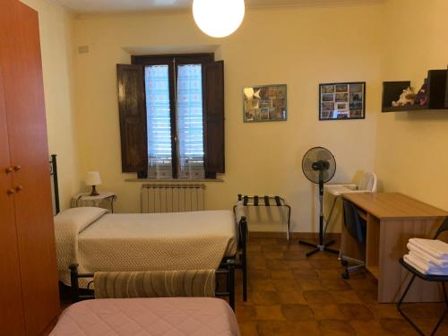 a room with two beds and a desk and a window at Appartamento il Leone in Empoli