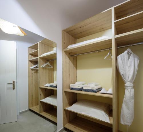a walk in closet with wooden shelves and towels at Acro Blue Luxury Villas in Akrotiri