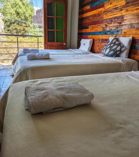 a group of three beds in a room at Sumaq Wari Hotel in Ayacucho