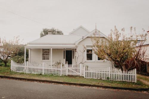 a white house with a white picket fence at The Allotment Albany - Centrally Located Cottage in Old Albany in Albany