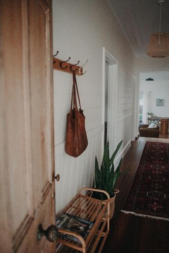 a hallway with a bench and a purse on the wall at The Allotment Albany - Centrally Located Cottage in Old Albany in Albany