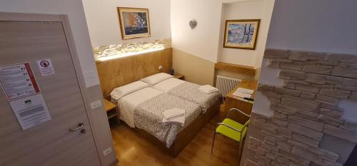a small room with a bed and a stone wall at Hotel Tarvisio Four Seasons in Tarvisio