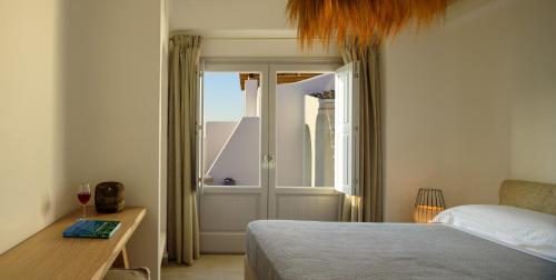 a bedroom with a bed and a door with a window at Acro Blue Luxury Villas in Akrotiri