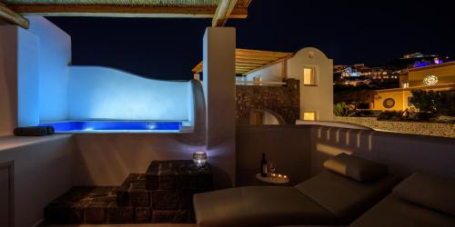 a balcony with a couch and a blue light at Acro Blue Luxury Villas in Akrotiri