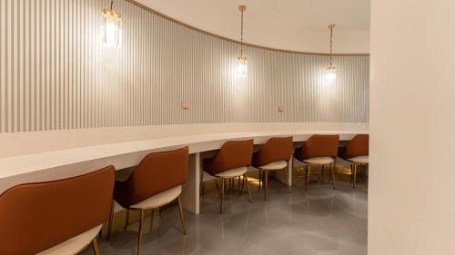 a row of chairs lined up against a long table in a room at Denbasta Central Hotel Seomyeon in Busan