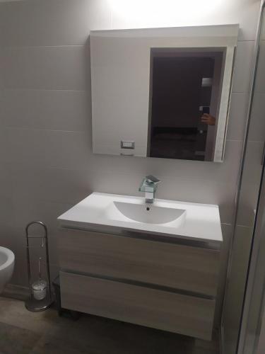 un baño con lavabo y espejo en Help, en Santeramo in Colle