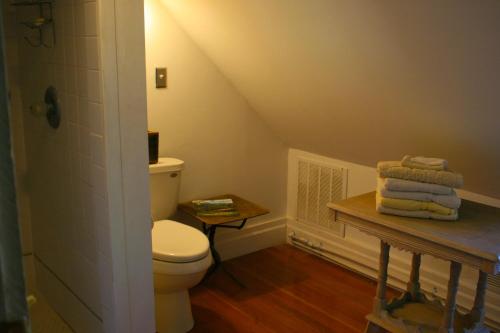 a bathroom with a toilet and a table with towels at Old Pioneer Garden Country Inn in Unionville