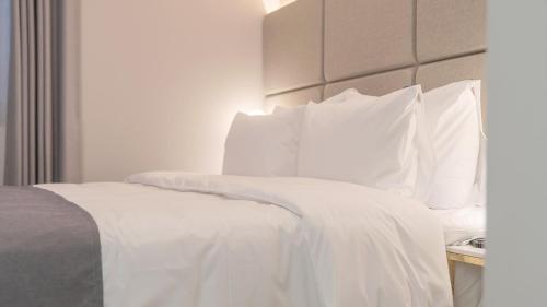 a white bed with white sheets and pillows at Denbasta Central Hotel Seomyeon in Busan