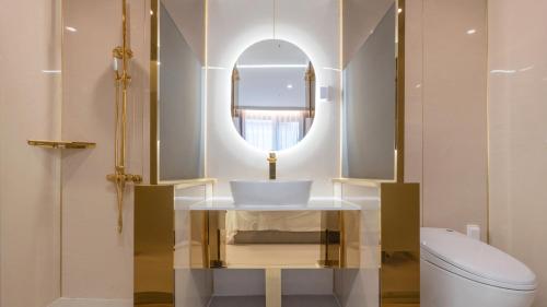 a bathroom with a sink and a mirror and a toilet at Denbasta Central Hotel Seomyeon in Busan