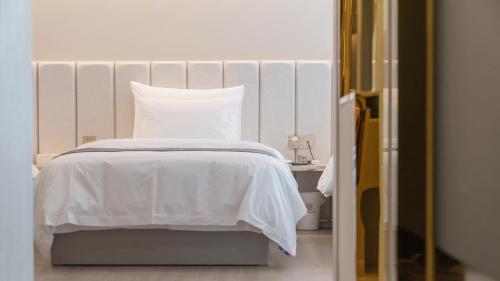 a bed with a white bedspread and a pillow at Denbasta Central Hotel Seomyeon in Busan
