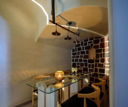 a dining room with a glass table and chairs at Acro Blue Luxury Villas in Akrotiri