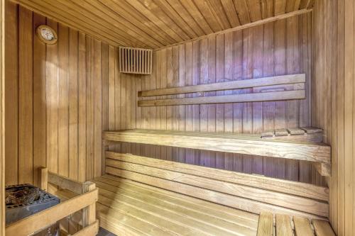 a wooden sauna with wooden shelves and a clock at Pool & Whirlpool Art Villas in Trebnje