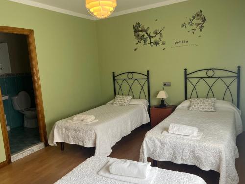 a room with three beds and a mirror at Casa la melliza VV-3021AS in Mestas de Con