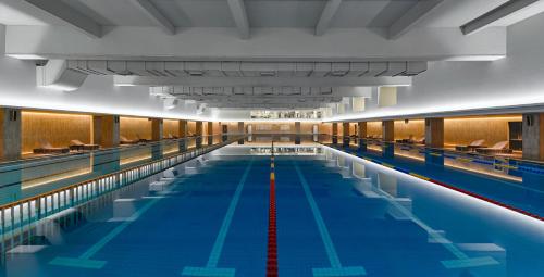 a large indoor swimming pool with blue water at Empark Grand Hotel Beijing in Beijing