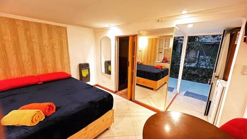 1 dormitorio con 1 cama y puerta corredera de cristal en Departamentos Arrayanes en El Bolsón