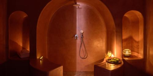 a bathroom with a shower with a sink and a table at Acro Blue Luxury Villas in Akrotiri