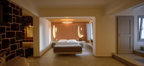 a bedroom with a bed and a brick wall at Acro Blue Luxury Villas in Akrotiri