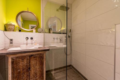 a bathroom with two sinks and a glass shower at Deichkind CitySuite in Bremen