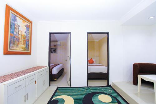 a room with a bedroom with two beds and a mirror at The Djakarta Anandita Syariah Hotel in Samarinda