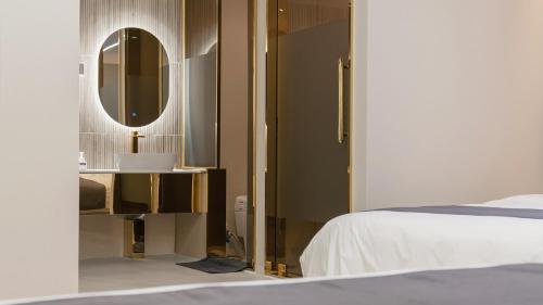 a bedroom with a bed and a mirror and a bed sidx sidx sidx at Denbasta Central Hotel Seomyeon in Busan