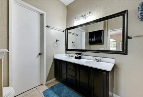 a bathroom with a sink and a mirror at Modern Family Home, Close to Typhoon Texas and Tesla Gigafactory in Pflugerville