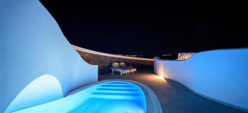 a room with a swimming pool at night at Acro Blue Luxury Villas in Akrotiri