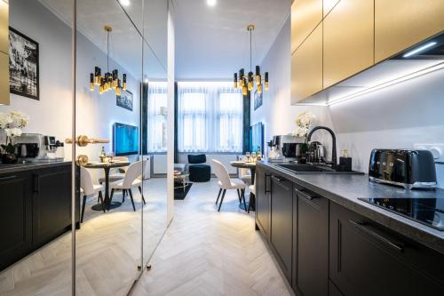 kuchnia z czarnymi szafkami i jadalnią w obiekcie Dasto Apartments Old Town Kraków w Krakowie