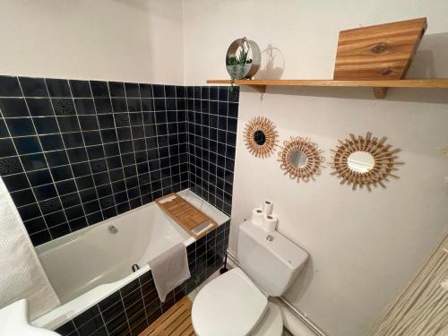 W łazience znajduje się toaleta, wanna i umywalka. w obiekcie Le Patio, coeur de ville avec garage et jardin w mieście Vannes