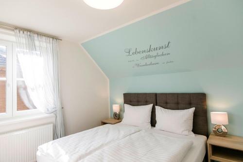 1 dormitorio con 1 cama con sábanas blancas y ventana en R&R Residenzen Ferienwohnungen, en Mitterbach