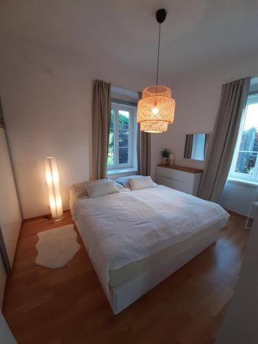 a bedroom with a large white bed and a chandelier at Ferienwohnung in Reifnitz am Wörthersee mit Seezugang in Reifnitz