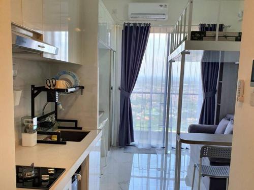 a kitchen with a large window with a view of a city at Cozy Studio @Skyhouse BSD in Samporo