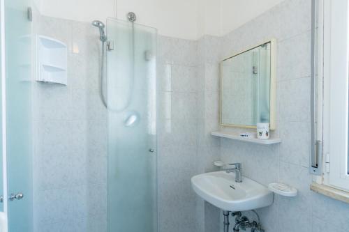 a white bathroom with a sink and a shower at Beach Suite Hotel in Bellaria-Igea Marina