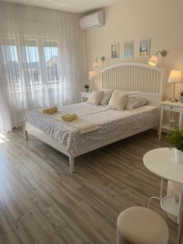 a bedroom with a large bed and two tables at Kosovic Family House in Medulin