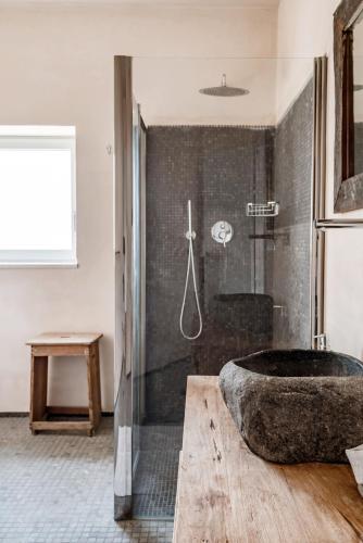 a bathroom with a large stone tub and a shower at Wp Relais apartments in Diso