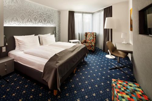 ein Hotelzimmer mit einem Bett und einem Schreibtisch in der Unterkunft Holiday Inn Dresden - City South, an IHG Hotel in Dresden