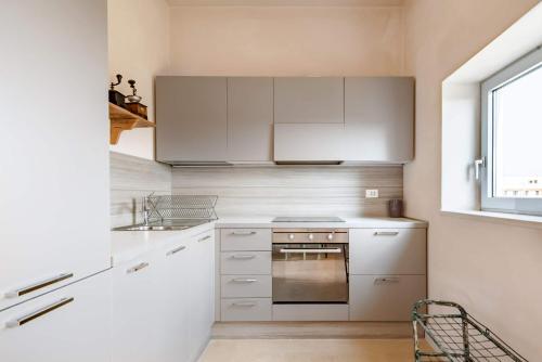 a kitchen with white cabinets and a sink and a stove at Wp Relais apartments in Diso
