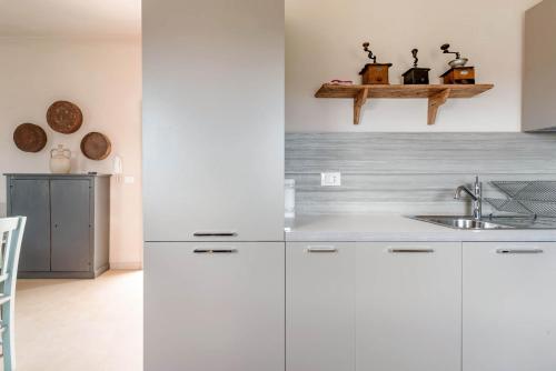 a kitchen with white cabinets and a sink at Wp Relais apartments in Diso
