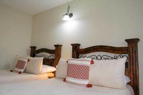 a bedroom with two beds with pillows at Hostal Donde Regina in Guatemala