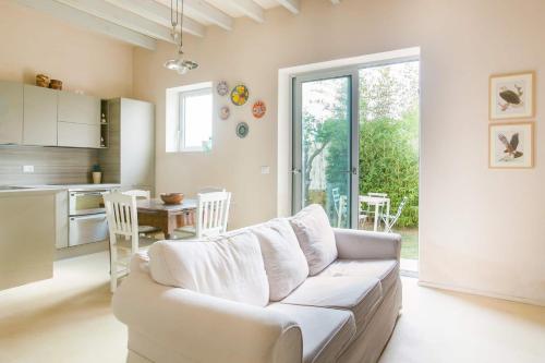 a living room with a white couch and a kitchen at Wp Relais apartments in Diso