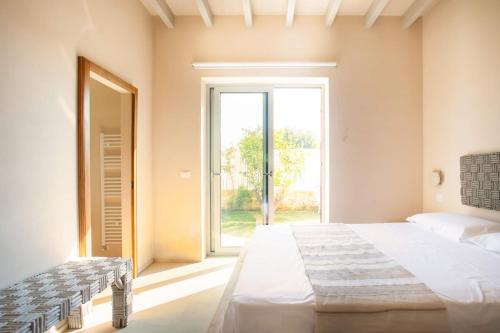 a bedroom with a large bed and a large window at Wp Relais apartments in Diso