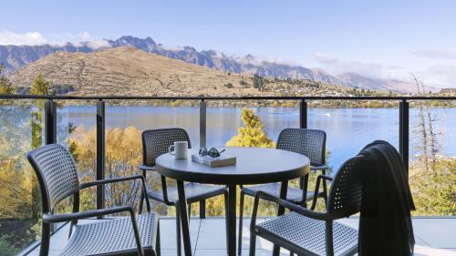 クイーンズタウンにあるOaks Queenstown Shores Resortのテーブルと椅子、水辺の景色を望むバルコニー