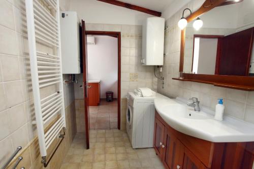 Un baño con lavabo y lavadora. en Apartment Roxor, en Portorož