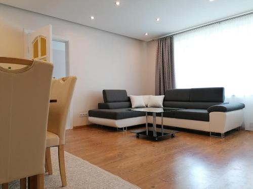 uma sala de estar com um sofá e uma mesa em Centro apartamentai em Zarasai