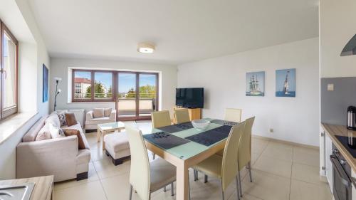 kuchnia i jadalnia ze stołem i krzesłami w obiekcie Apartamenty Sun & Snow Lido Sarbinowo w Sarbinowie